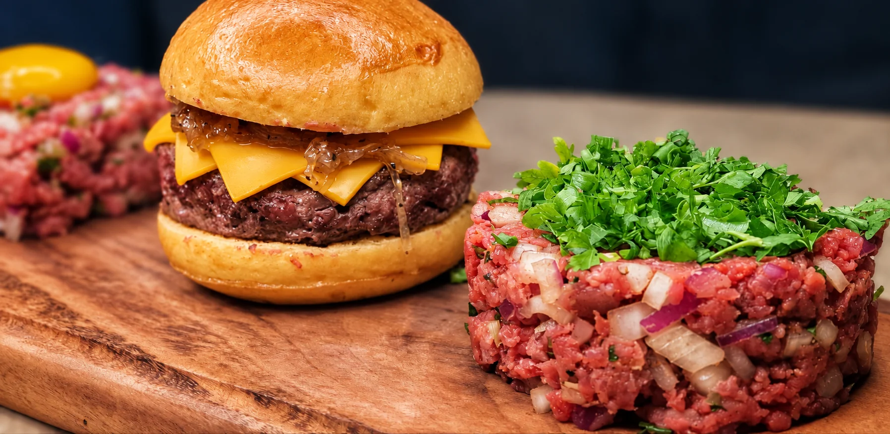 Detalhes da tábua com hambúrguer, carne de onça e steak tartar